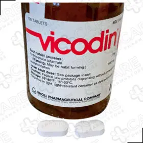 A bottle of Vicodin pills with white background you can buy vicodin 5/500mg online